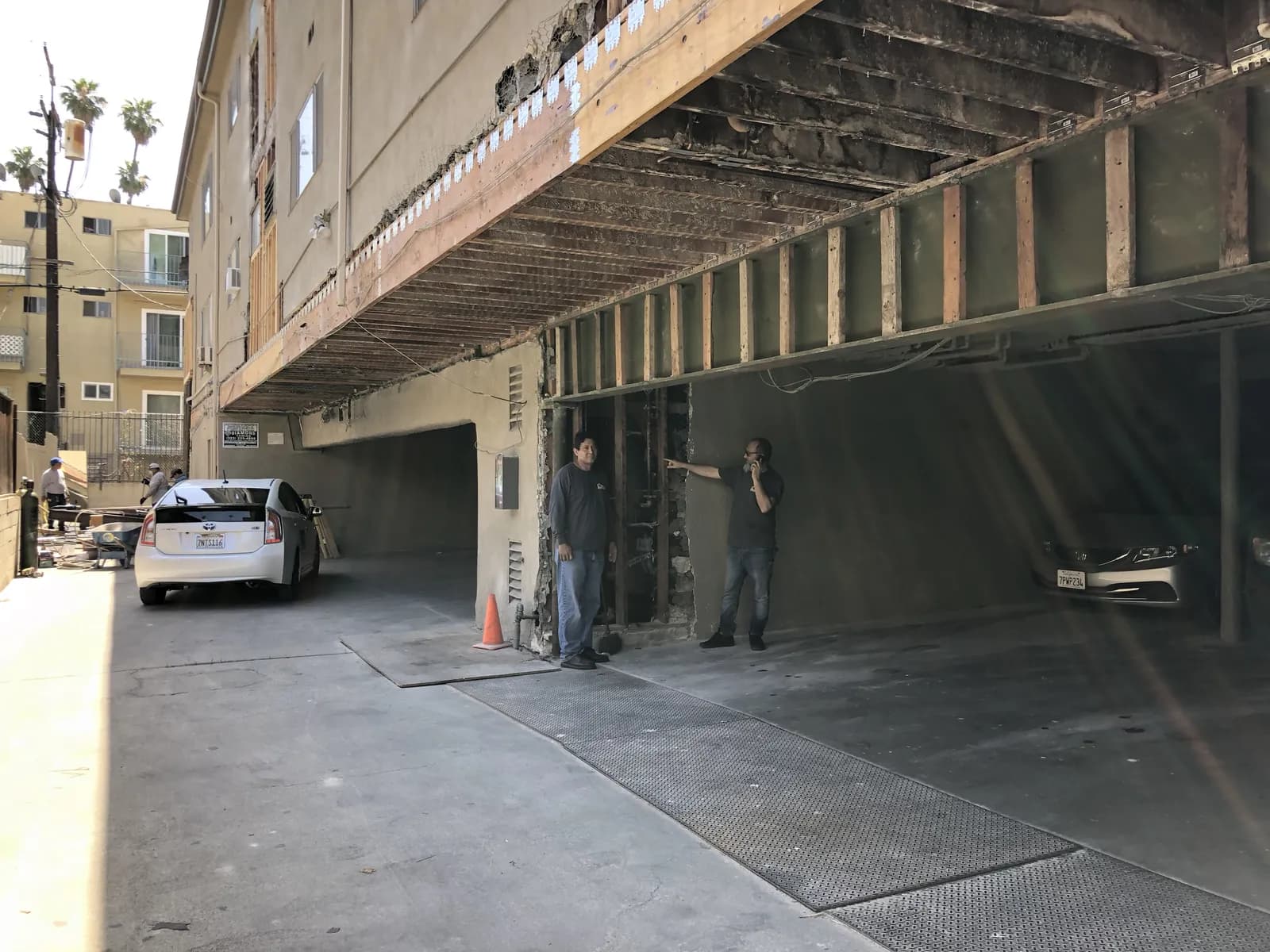 Cal Retrofit walking a property owner through the exposed underside of a soft-story building during a site assessment.