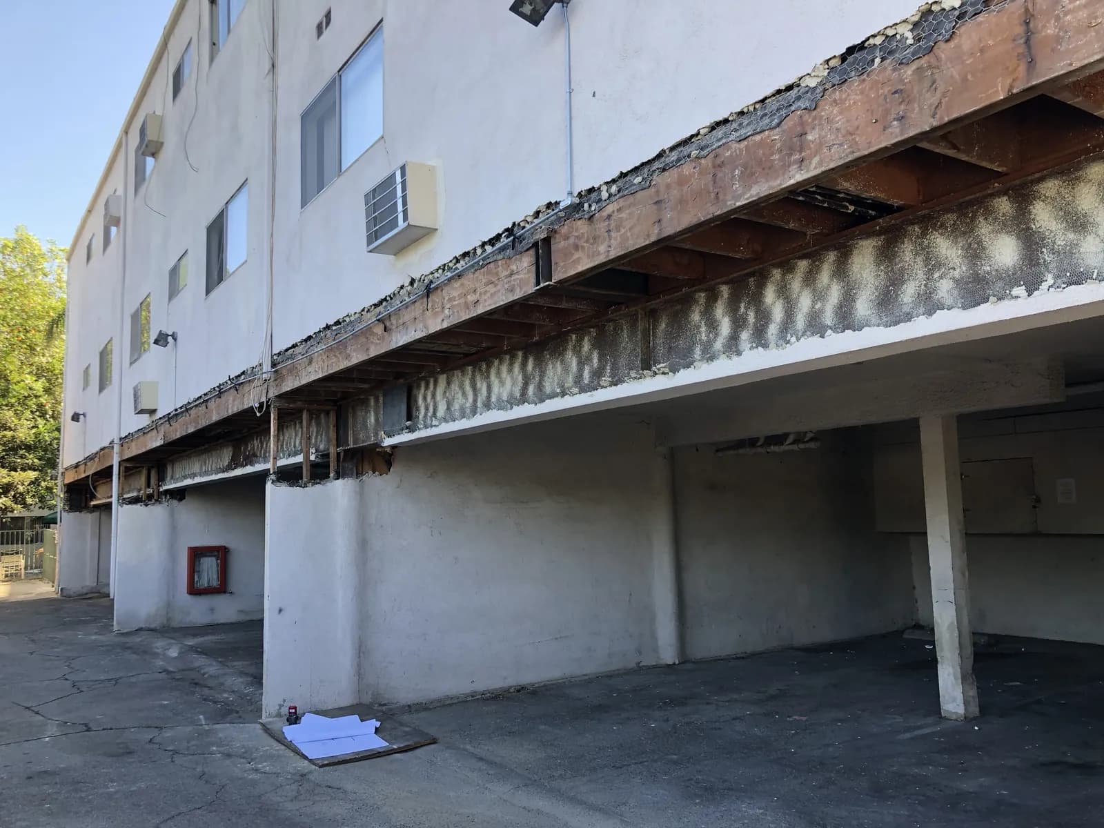 Elevated walkway with the soffit removed, exposing the framing before balcony repair and waterproofing