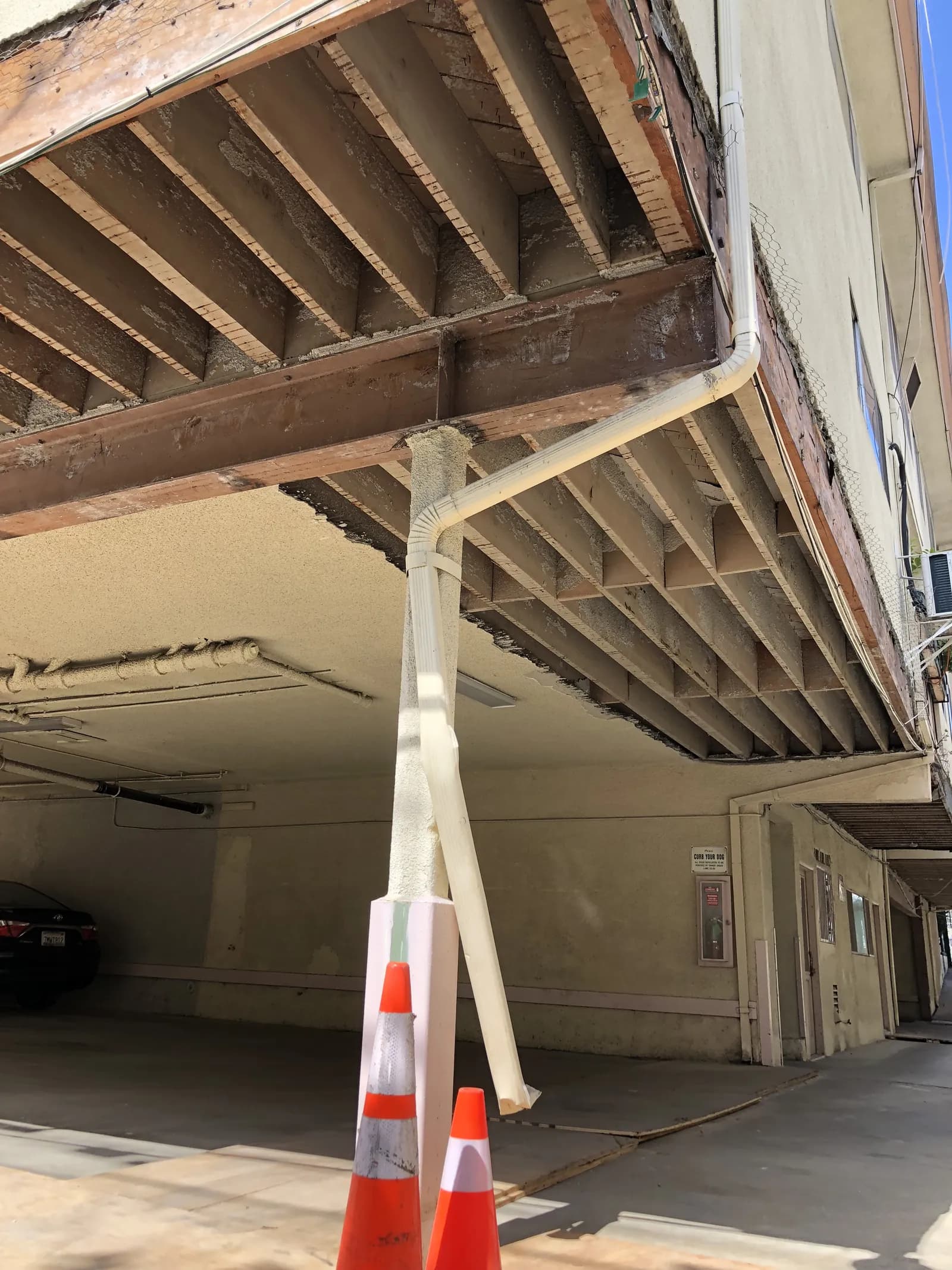 Exposed cantilever framing at the underside of an elevated walkway during balcony repair